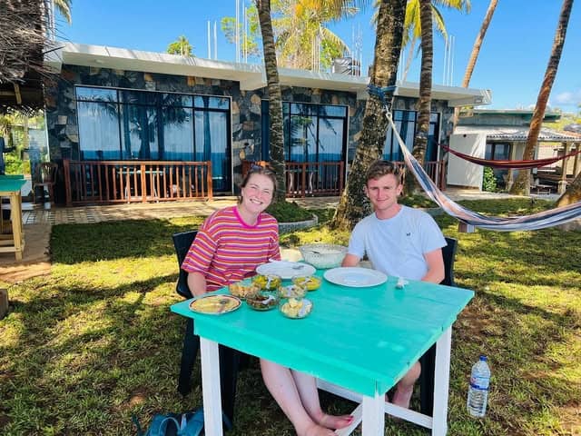 Two guests at breakfast in front of the rooms